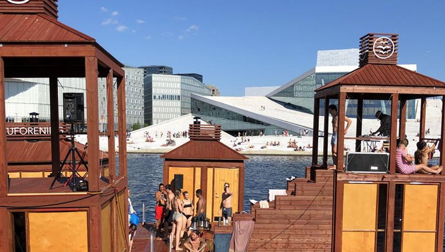 A floating wooden sauna on a Norwegian fjord at sunset