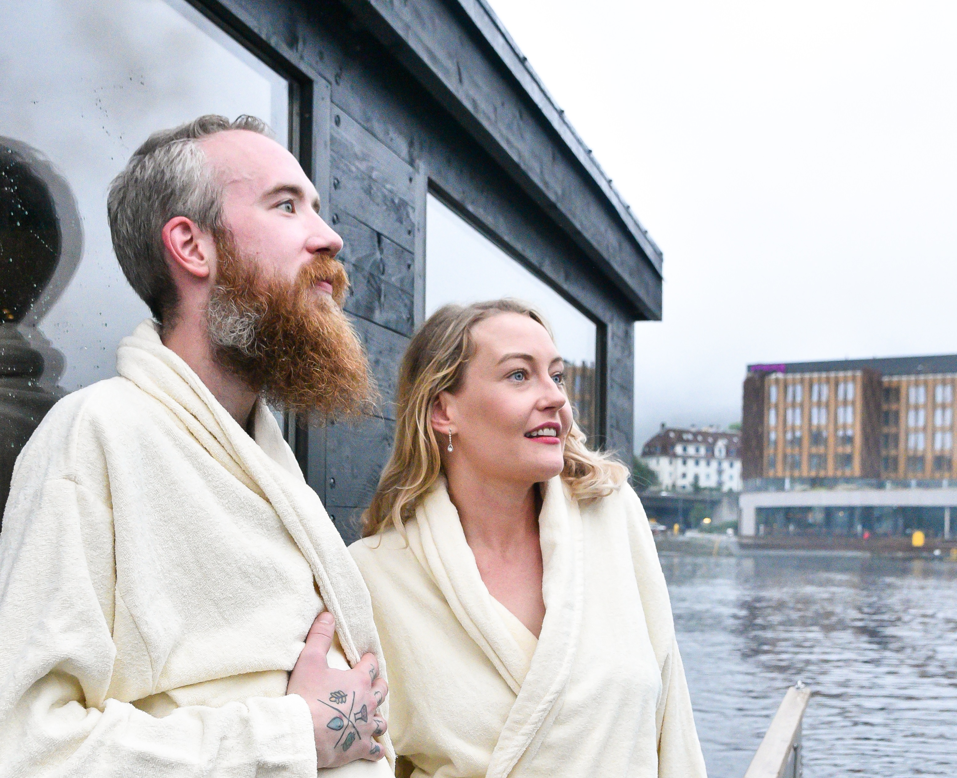 A floating sauna on Bergen harbour with the seven mountains and Bryggen wharf in the background