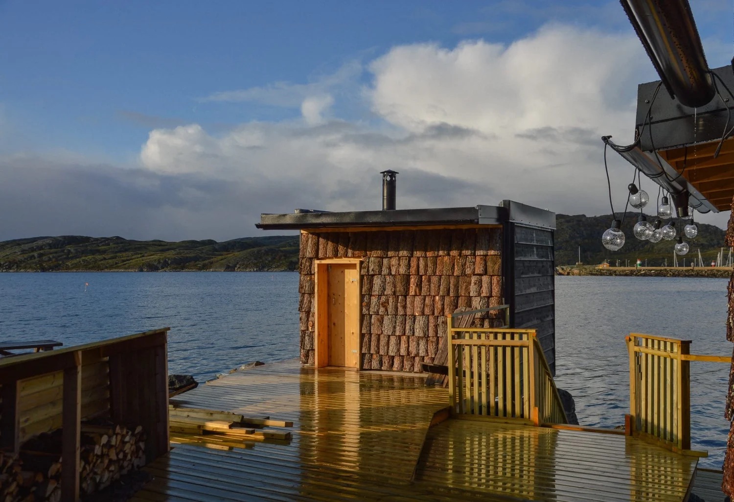 Volunteer-run community sauna on Bodø's waterfront with the Vestfjord and distant Lofoten peaks behind