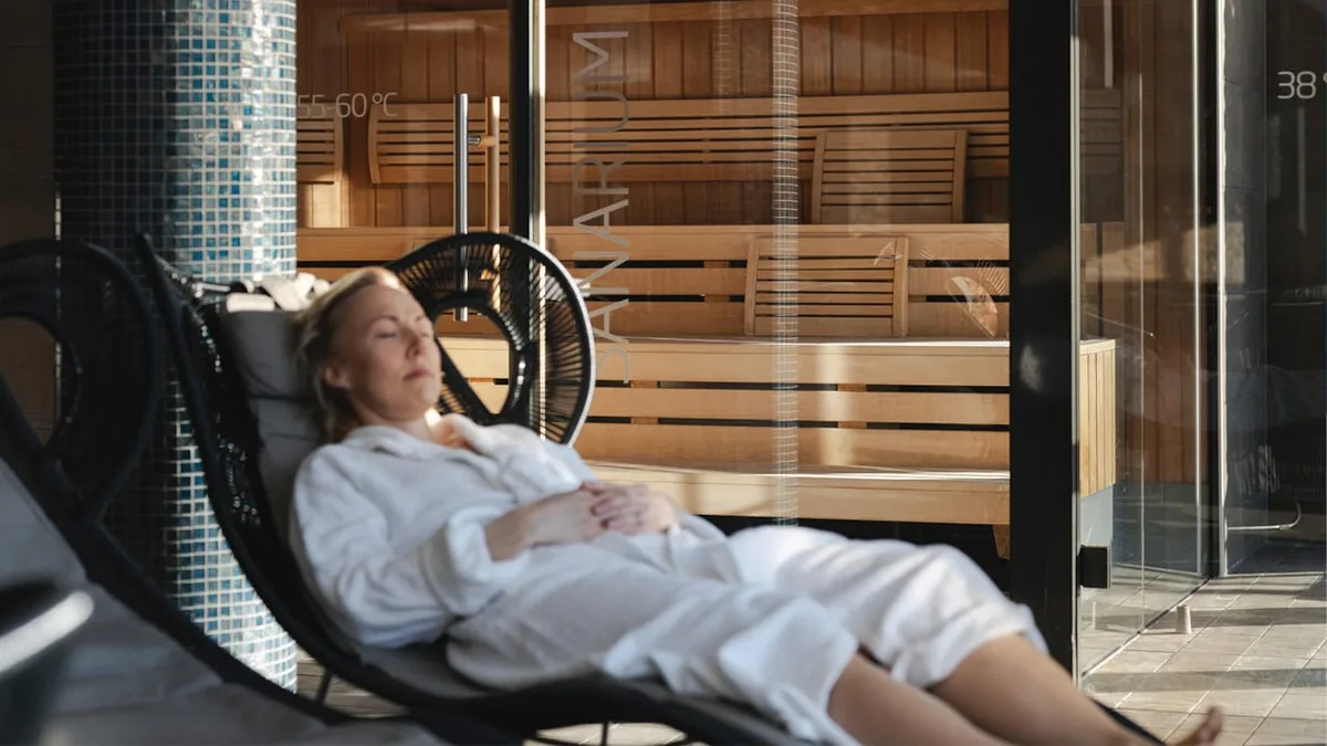 Steam rising from a Norwegian sauna surrounded by snow-covered pine forest