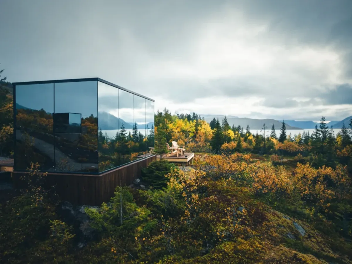 A private wooden sauna on a Norwegian fjord at dusk with soft light reflecting on calm water